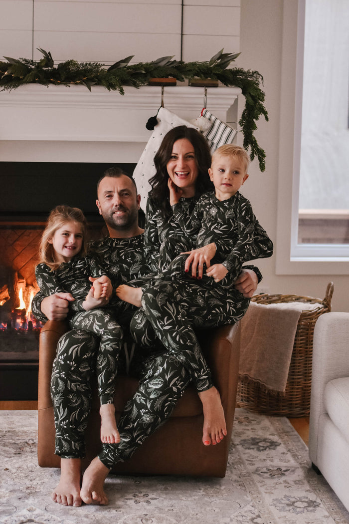 a family sitting together in matching christmas pajamas