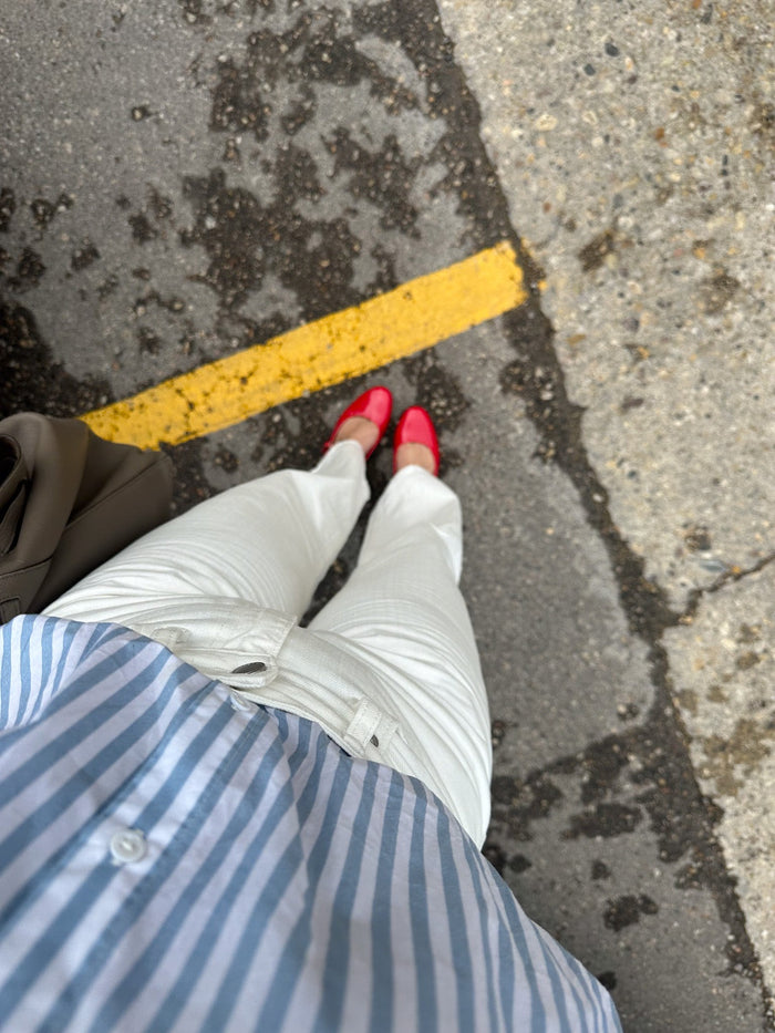 woman wearing red ballet flats shopping at the farmers market